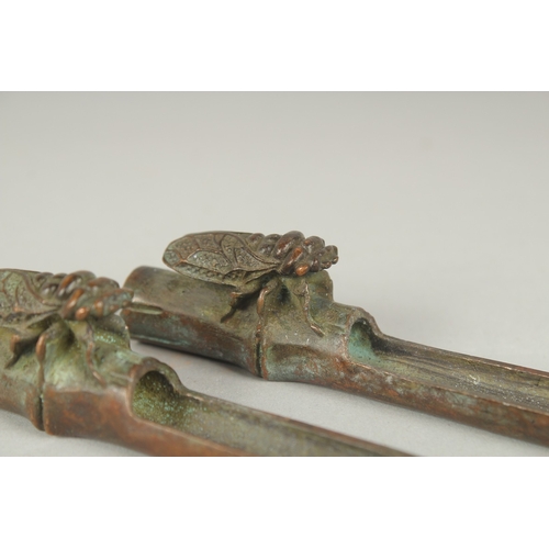 84 - A PAIR OF JAPANESE BRONZE PAPERWEIGHTS, with an insect on bamboo, the underside with mark, 19cm long... 