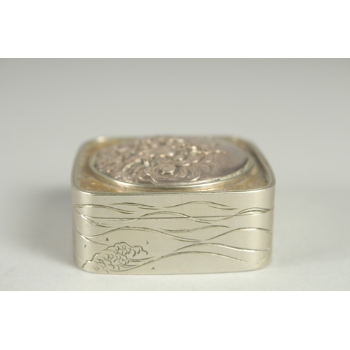 86 - A SMALL SIGNED JAPANESE WHITE METAL AND BRASS BOX, the hinged lid with relief dragon roundel, 5cm sq... 