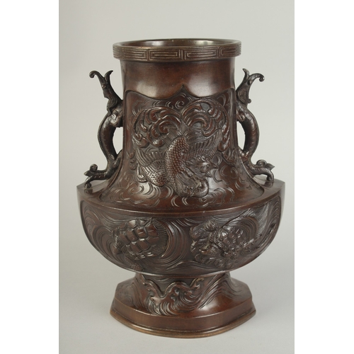 89 - AN UNUSUAL BRONZE TWIN HANDLE DRAGON AND PHOENIX VASE, with panels of relief decoration including a ... 
