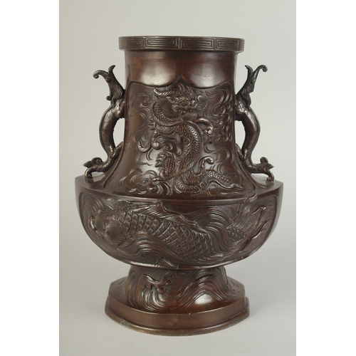 89 - AN UNUSUAL BRONZE TWIN HANDLE DRAGON AND PHOENIX VASE, with panels of relief decoration including a ... 