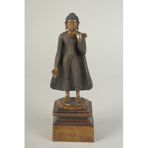 90 - A FINELY FETTLED BRONZE STANDING BUDDHA, fitted to a lotus base plinth, 21cm high.