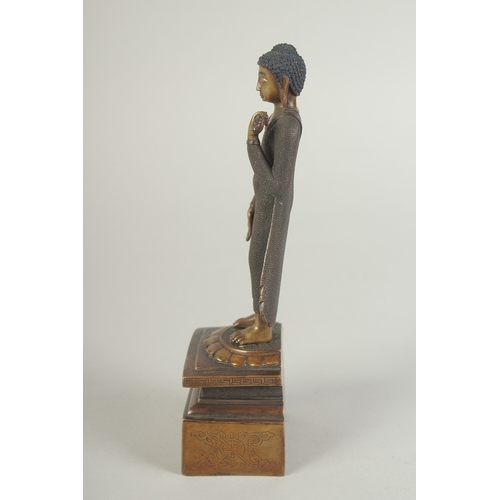 90 - A FINELY FETTLED BRONZE STANDING BUDDHA, fitted to a lotus base plinth, 21cm high.