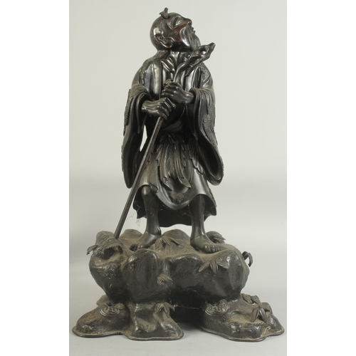 92 - A LARGE 19TH CENTURY CHINESE BRONZE FIGURE OF LI TIEGUAI, elevated upon a large rock-formed bronze b... 