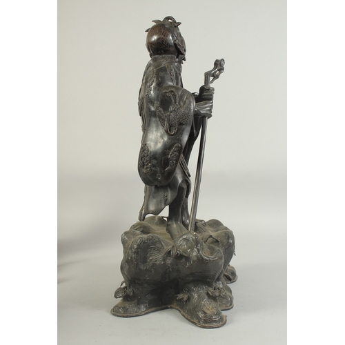 92 - A LARGE 19TH CENTURY CHINESE BRONZE FIGURE OF LI TIEGUAI, elevated upon a large rock-formed bronze b... 