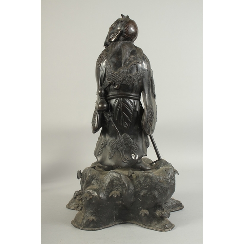 92 - A LARGE 19TH CENTURY CHINESE BRONZE FIGURE OF LI TIEGUAI, elevated upon a large rock-formed bronze b... 