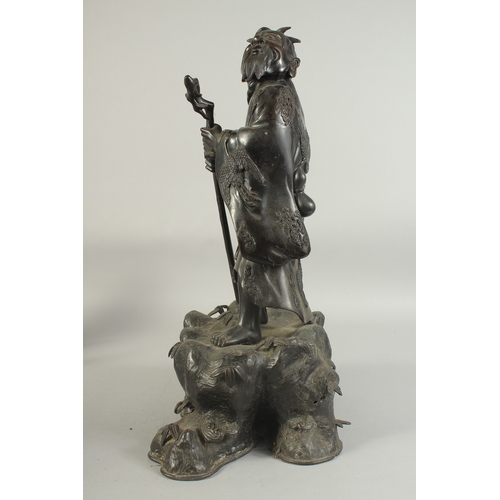 92 - A LARGE 19TH CENTURY CHINESE BRONZE FIGURE OF LI TIEGUAI, elevated upon a large rock-formed bronze b... 