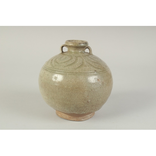 97 - A CHINESE CELADON GLAZED POTTERY TWIN HANDLE VESSEL, with carved decoration to the shoulder, 15cm hi... 