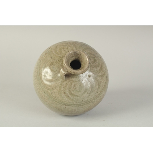 97 - A CHINESE CELADON GLAZED POTTERY TWIN HANDLE VESSEL, with carved decoration to the shoulder, 15cm hi... 