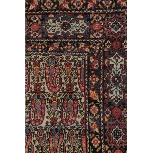 1006 - A GOOD PERSIAN RUG cream ground with stylised Boteh design. 6ft 5ins x 4ft 8ins.