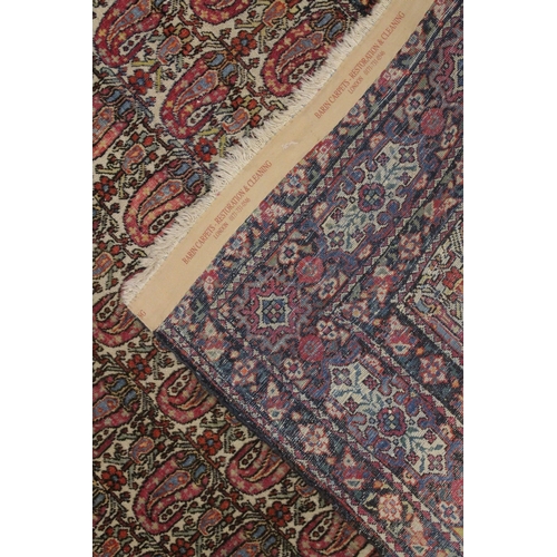 1006 - A GOOD PERSIAN RUG cream ground with stylised Boteh design. 6ft 5ins x 4ft 8ins.