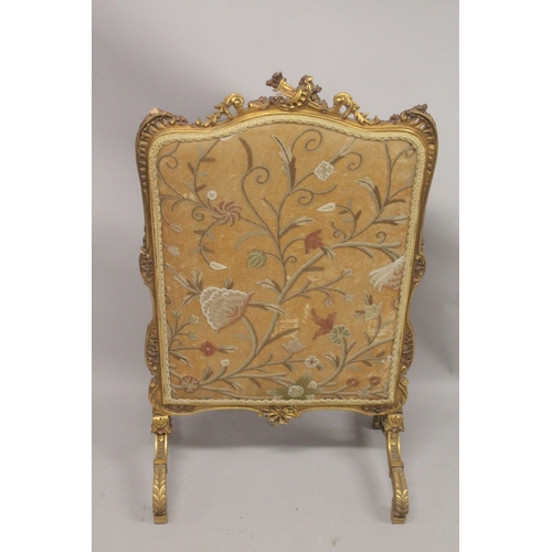 1043 - A FRENCH CARVED AND GILDED FIRE SCREEN with needlework panel. 3ft 6ins high, 2ft wide.