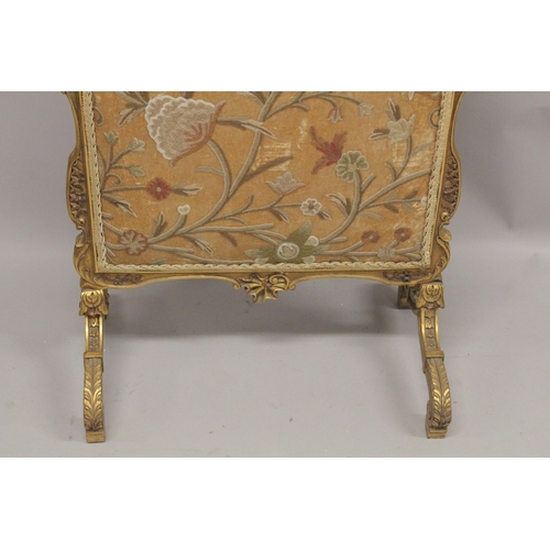 1043 - A FRENCH CARVED AND GILDED FIRE SCREEN with needlework panel. 3ft 6ins high, 2ft wide.