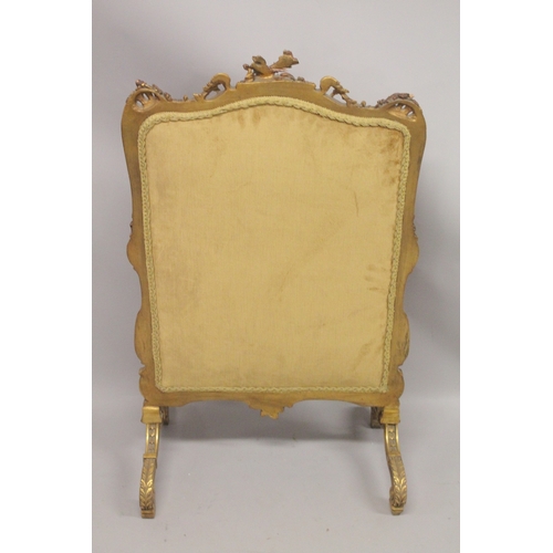 1043 - A FRENCH CARVED AND GILDED FIRE SCREEN with needlework panel. 3ft 6ins high, 2ft wide.