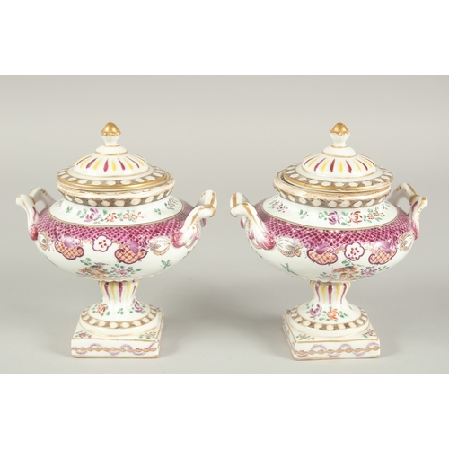 1102 - A SMALL PAIR OF SAMSON OF PARIS TWO HANDLED URNS AND COVERS with famille rose decoration and flowers... 