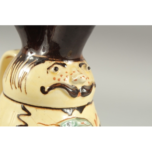 1106 - A HUNGARIAN ART POTTERY MISKO WINE JUG with a man's  face and snake. Signed.  9ins high.