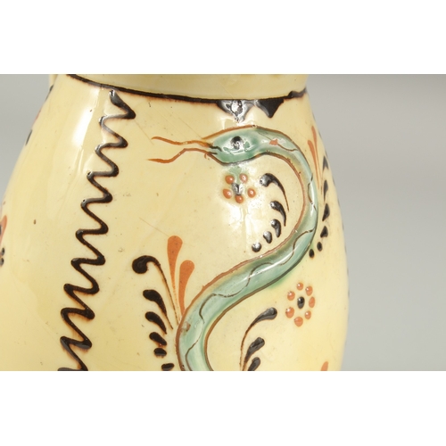 1106 - A HUNGARIAN ART POTTERY MISKO WINE JUG with a man's  face and snake. Signed.  9ins high.