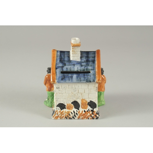 1107 - A PRATT WARE POTTERY HOUSE with blue roof, two men standing at the side of the house. 4.5ins high.... 