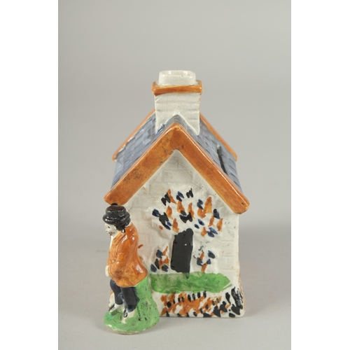 1107 - A PRATT WARE POTTERY HOUSE with blue roof, two men standing at the side of the house. 4.5ins high.... 