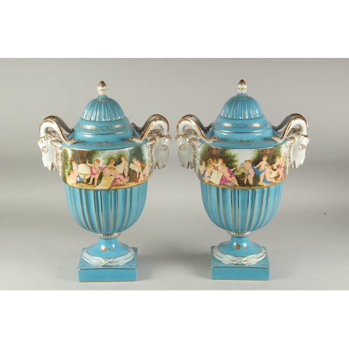 1115 - A LARGE PAIR OF SEVRES LIGHT BLUE TWO HANDLED URN SHAPE PORCELAIN VASES with rams mask handles and p... 