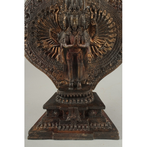 1157 - A CHINESE BRONZE MULTI ARMED FIGURE with a shrine. 1ft6ins high.