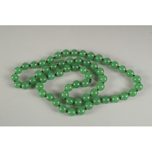 1182 - A STRING OF JADE BEADS.  24ins long.