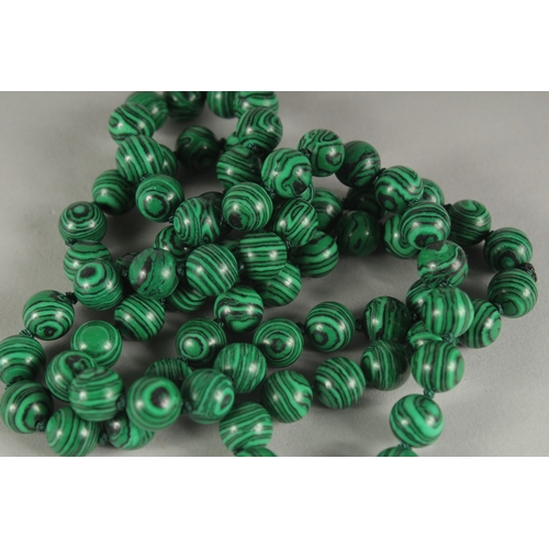 1184 - A STRING OF EIGHTY MALACHITE BEADS. 30ins long.