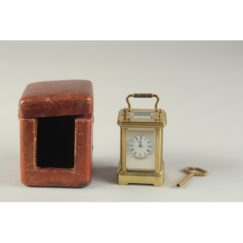 1231 - A MINIATURE BRASS CARRIAGE CLOCK, with white enamel dial and leather travelling case. 3ins high incl... 