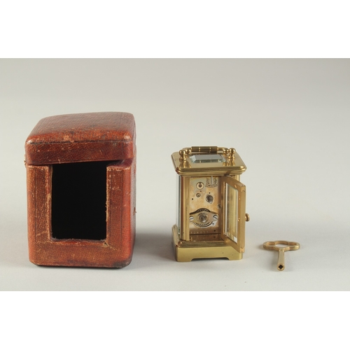 1231 - A MINIATURE BRASS CARRIAGE CLOCK, with white enamel dial and leather travelling case. 3ins high incl... 