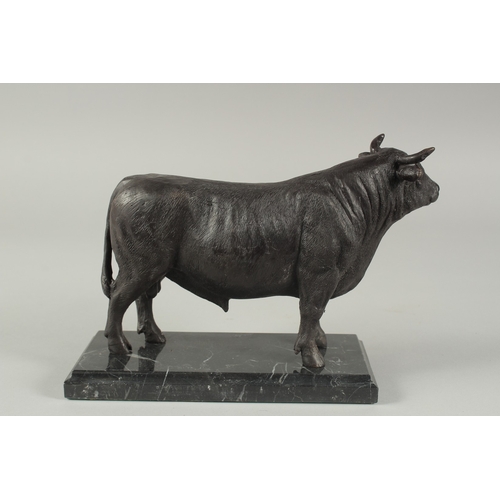 1257 - A BRONZE STANDING BULL on a marble base.  9ins high.