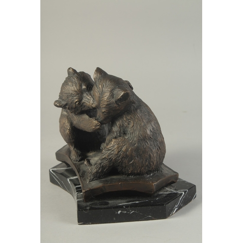 1272 - A CAST BRONZE GROUP OF TWO PLAYFUL BEARS on a  marble base. 7ins high.