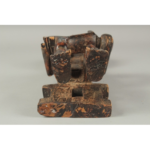 1281 - A CARVED AFRICAN FIGURE OF A WOMAN SITTING ON A BENCH, feeding a baby. 14ins high.