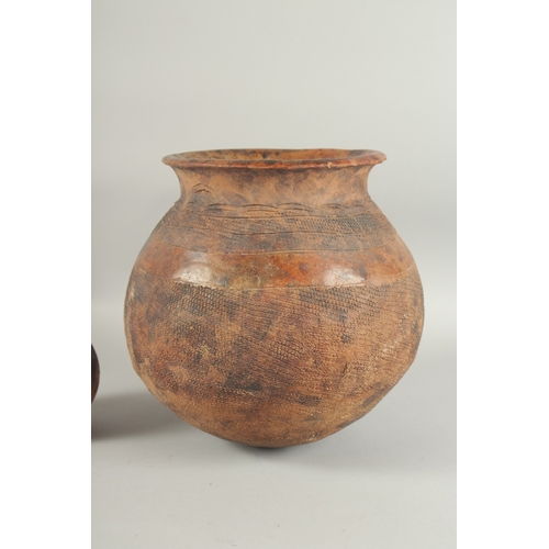 1287 - A LARGE AFRICAN BROWN POTTERY POT. 11ins and another pot, 5ins. (2)