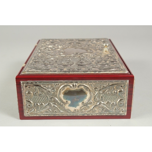 1297 - A GOOD REPOUSSE SILVER CASKET, silver top and sides with velvet interior. 9.5ins long, 6.5ins wide, ... 