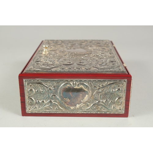 1297 - A GOOD REPOUSSE SILVER CASKET, silver top and sides with velvet interior. 9.5ins long, 6.5ins wide, ... 