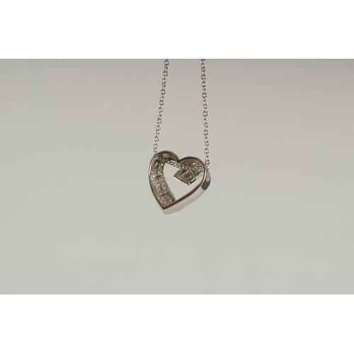 1580 - A 14CT WHITE GOLD AND DIAMOND HEART SHAPED PENDANT on a chain.