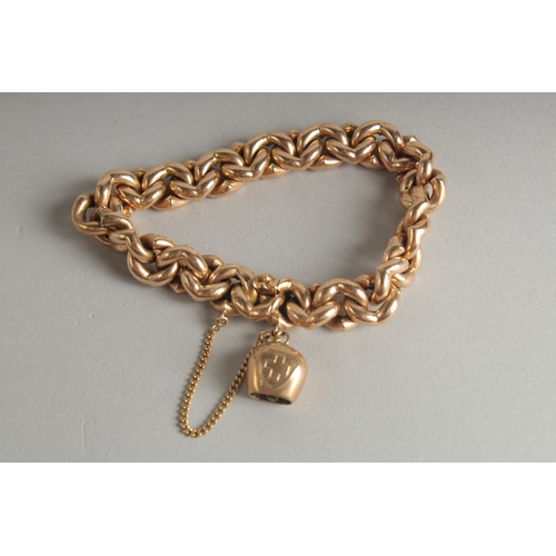 1595 - A 15CT GOLD CHAIN LINK BRACELET and a charm. Weight: 28.9gms.