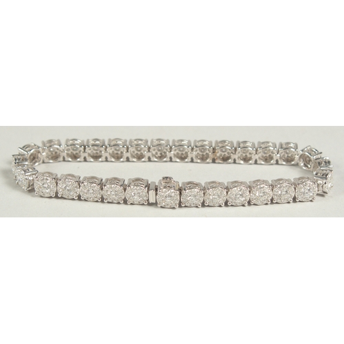 1599 - A SUPERB 18 CARAT WHITE GOLD, ILLUSION SET DIAMOND, LINE BRACELET with 30 cluster set diamonds. 20cm... 