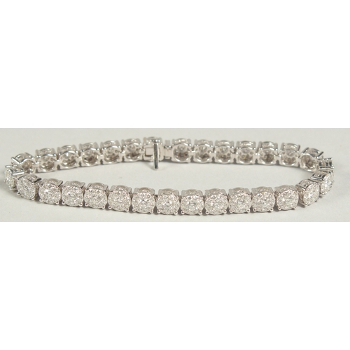 1599 - A SUPERB 18 CARAT WHITE GOLD, ILLUSION SET DIAMOND, LINE BRACELET with 30 cluster set diamonds. 20cm... 