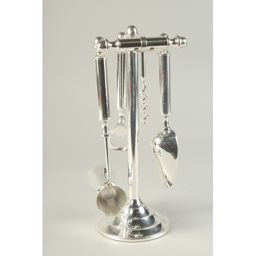 1693 - A SILVER PLATED STAND MOUNTED WITH BAR ACCESSORIES.  10.5ins high.