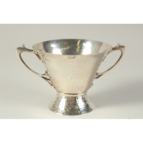 1701 - AN ART DECO HAMMERED TWO HANDLED SILVER BOWL. 4.5ins diameter, London 1904, maker: W.K.S. Weight: 8o... 