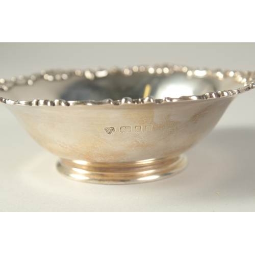 1705 - A CIRCULAR SILVER BOWL with cast rim.  4.75ins diameter. London 1935,  and a small cup. Birmingham 1... 