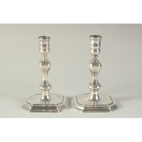 1755 - A MATCHED PAIR OF GEORGE I SILVER AND GEORGE II SILVER CAST CANDLESTICKS. London 1725 & 1735.  Maker... 