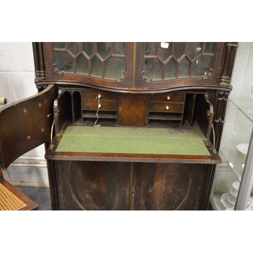 173 - An impressive Chippendale Revival mahogany serpentine fronted cupboard bookcase with secretaire draw... 