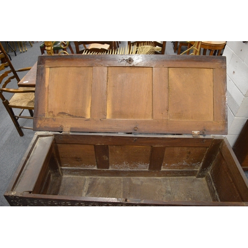 251 - A 17th century oak coffer with triple panelled rising top above a triple panelled front with carved ... 