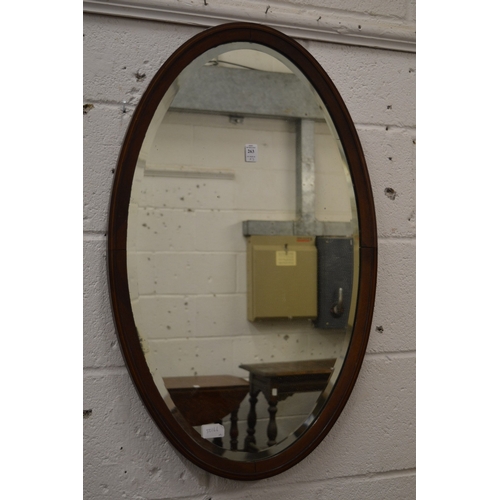 263 - A mahogany framed oval wall mirror and a Victorian walnut over-mantel mirror.