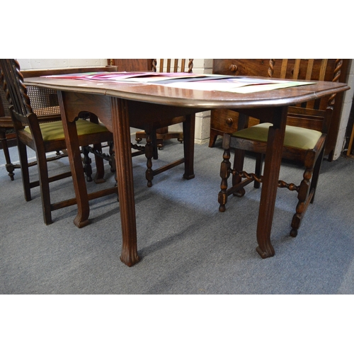 290 - An oak drop-leaf gateleg dining table and four oak dining chairs.