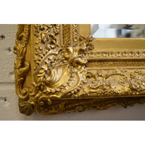 295 - A decorative large gilt framed rectangular wall mirror.