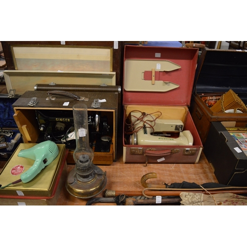 614 - A good collection of miscellaneous items to include sewing machines, walking sticks etc.