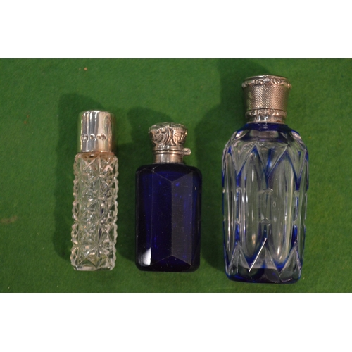 765 - Three cut glass scent bottles with silver mounts.