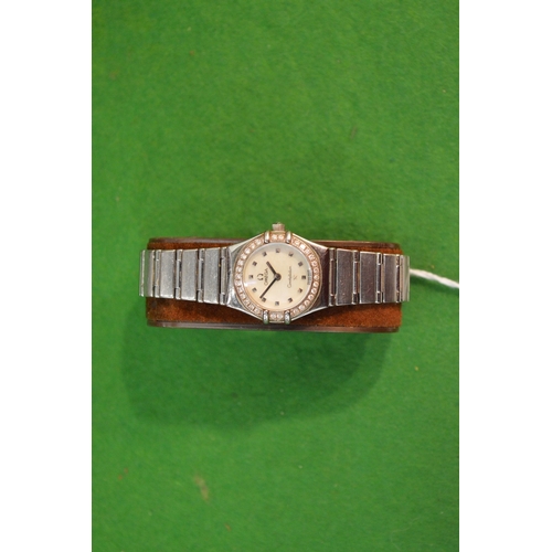 774 - A ladies Omega Constellation stainless steel wrist watch with diamond set bezel.